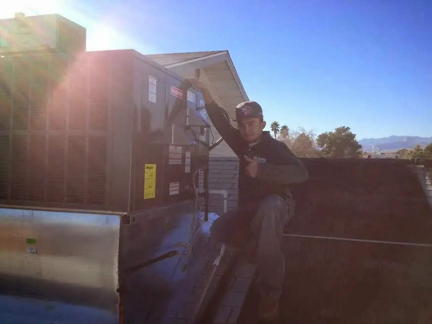 HVAC technician performing Air Duct Cleaning on a rooftop unit in Lake Villa